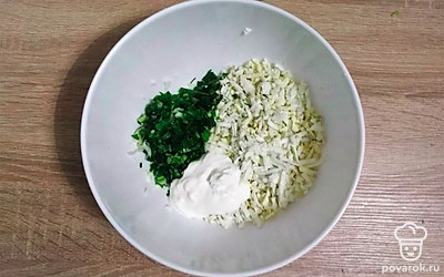 Для яичной начинки отваренные яйца и зелень мелко порубите ножом, добавьте 2 столовые ложки сметаны, посолите и хорошо перемешайте.