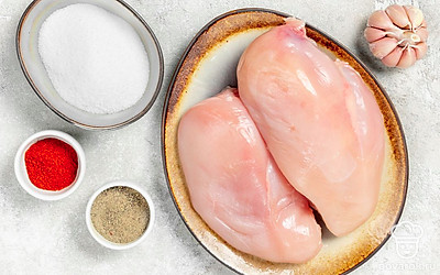 Куриную грудку промойте, аккуратно отделите мясо от кости и снимите кожу. Удалите прожилки и насухо оботрите бумажным полотенцем. Чеснок почистите, помойте и пропустите через пресс. Подготовьте пищевую пленку, чистую хлопковую ткань, плотную нить, пластиковый хомут или проволоку из нержавеющей стали.