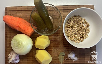 Поставьте на медленный огонь говяжью кость, промойте перловку и оставьте в холодной воде. На час или пока мясо не будет отходить от кости. Почистите овощи. 