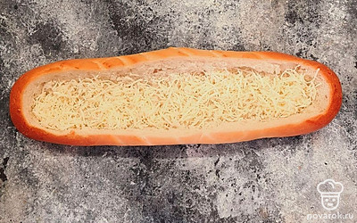 На дно кладем половину натертого сыра.