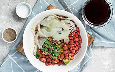 Соберите блюдо. В глубокую миску выложите готовую фасоль. Репчатый лук очистите от шелухи, нарежьте тонкими полукольцами, а затем добавьте к фасоли. Туда же влейте ароматную заправку. Все ингредиенты тщательно перемешайте.