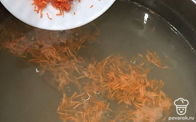 Из бульона достать мясо. Процедить бульон. Далее добавить натертую морковь и варить 5 минут.