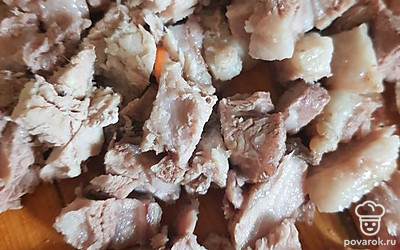 Достать и нарезать свинину. Картошку и пережарку отправить в кастрюлю, по вкусу можно положить смесь перцев. Нарезанное мясо закинуть в суп. Варить до готовности.