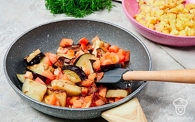 Приготовьте обжарку. На другой сковороде растопите оставшееся сливочное масло. Потушите на среднем огне баклажаны 15 минут, добавьте помидор и потушите еще 5 минут.