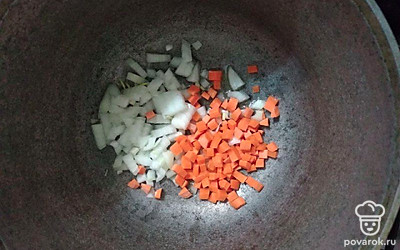 Одну морковь и один лук порежьте кубиками. Обжарьте их в казане с подсолнечным маслом.