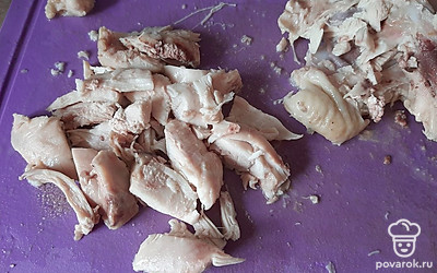 Достаем готовые куриные бедра, разделяем на части и кладем обратно в кастрюлю.