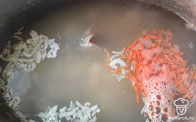Через 7 минут добавить мелко нарезанный лук и натертую на терке морковь.