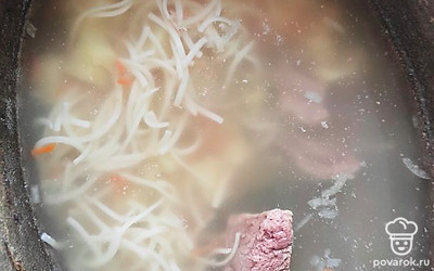 Через пару минут добавить лапшу, выключить огонь, оставить настояться 10 минут. Мясо измельчить на удобные кусочки и отправить обратно в суп. 