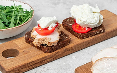 Сделайте сэндвичи. На один кусок хлеба выложите индейку, кружочки помидора и ломтик сыра. Затем на второй кусочек хлеба положите оставшиеся помидоры и буррату. Положите куски хлеба на тарелку и уберите в микроволновку на 30 секунд. На один кусок хлеба положите рукколу. Соедините кусочки, второй положите поверх первого.