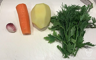 Тем временем подготавливаем овощи и зелень. Картофель, чеснок и морковь очищаем, зелень промываем.