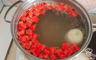 Почистим морковь и картофель, нарежем кубиками. Лук почистим. Высыпаем всё в кастрюлю и варим на среднем огне.