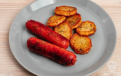 Выложите картофель и сосиски на тарелку. Добавьте салат из свежих овощей, чтобы сбалансировать прием пищи.