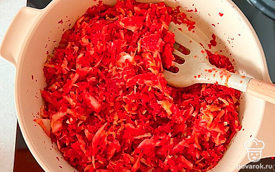 Добавьте нарезанную капусту, посолите, добавьте сушеный перец и оставьте тушиться под крышкой до готовности капусты.