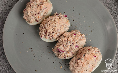 Готовые фаршированные яйца с горбушей и луком выложите на сервировочную тарелку и подавайте к столу.