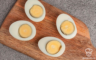 Яйца отварите вкрутую в течение 5-7 минут, почистите и разрежьте пополам.