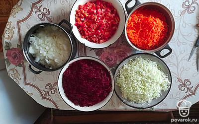 Свеклу и морковь очистите и натрите их на крупной терке. Капусту нашинкуйте , нарежьте лук полукольцами. У помидоров удалите плодоножки и нарежьте средними кубиками.