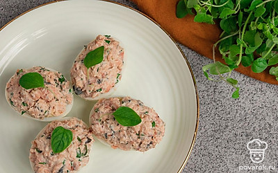 Готовые фаршированные яйца выложите на сервировочную тарелку и подавайте к столу.