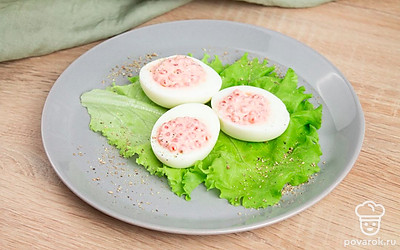 Переложите яйца на тарелку на листья салата, сверху посыпьте перцем по вкусу. Блюдо готово!