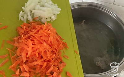 Лук и морковь почистить. Лук мелко нарезать, морковь натереть на крупной терке. Овощи соединить с бульоном.