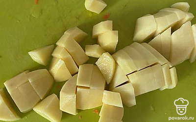 Картофель помыть, очистить, нарезать кубиками и отправить в кастрюлю.