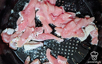 Куриное филе нарежьте длинной соломкой. Половину очищенного чеснока нарежьте мелкими кубиками. На разогретой сковороде в растительном масле обжарьте чеснок, и нарезанное куриное филе в течение 4 минут.