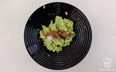 Авокадо нарежьте кусочками и сложите в удобную емкость. Добавьте к авокадо оставшийся чеснок и лимонный сок. С помощью блендера сделайте пюре, и добавьте кориандр, соль и черный молотый перец по вкусу. Перемешайте.