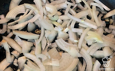 Нарежьте лук тонкими полукольцами. Отправьте лук на сковороду в разогретое масло и обжарьте до легкого румяного цвета. 