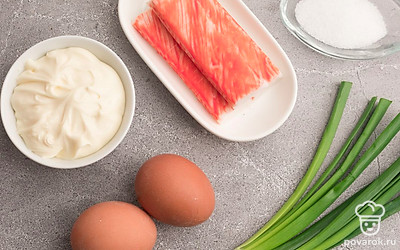 Отварите куриные яйца вкрутую и очистите. Снимите упаковку с крабовых палочек. Зеленый лук помойте и обсушите.