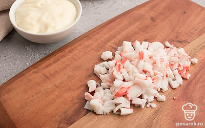 Мелко нарежьте крабовые палочки. Зеленый лук нашинкуйте тонкими колечками.