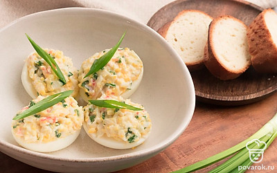 Наполните половинки яиц получившейся начинкой. Выложите фаршированные яйца на тарелку и украсьте тонкими перышками зеленого лука. Готово. Приятного аппетита!