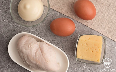 Отварите филе куриной грудки в подсоленной воде до готовности в течение 15-20 минут, а затем остудите. Куриные яйца отварите вкрутую и очистите. Сыр для блюда вы можете использовать любой по вашему вкусу, например, гауду, голландский или костромской.