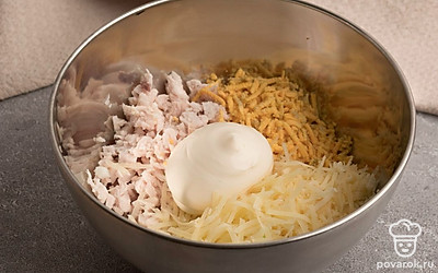 Натрите сыр на мелкой терке. В миску выложите мелко нарезанное куриное филе, тертый сыр и измельченные желтки. Добавьте майонез и все перемешайте.