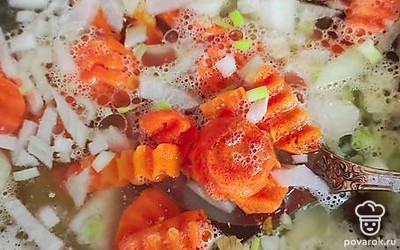 Картофель закипает. Режем кубиком морковь и репчатый лук, отправляем к картофелю. Через 5 минут отправляем нарезанное мясо обратно в кастрюлю.