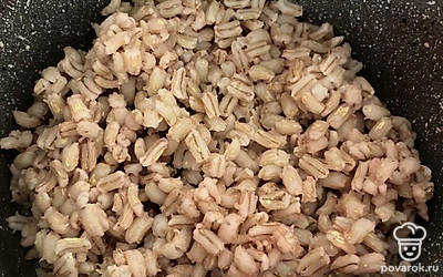 Добавьте содержимое сковородки в кастрюлю с бульоном. Варите еще минут 10. Выложите готовую перловку, нарезанный чеснок. Проварите минуты 2-3.