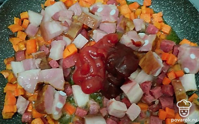 Отправляем копчености в сковороду и тушим, помешивая 5-7 минут. Добавляем томатную пасту и соус барбекю.