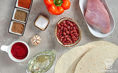 Вымойте филе индейки, обсушите, удалите пленки, положите мясо в кастрюлю с водой и варите его 30 минут. Почистите и помойте чеснок. Сполосните болгарский перец и удалите из него семена. Откройте банку с фасолью и слейте жидкость. Налейте на сковороду подсолнечное масло, поставьте ее на огонь.