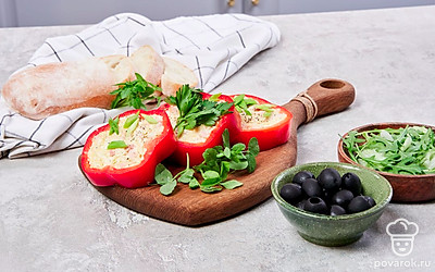 Перед подачей нарежьте фаршированные перцами колечками толщиной около 1 см. Сервировочную тарелку застелите салатными листьями, выложите закуску, присыпьте измельченным зеленым луком и петрушкой.