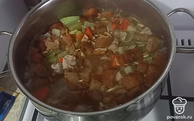 Добавьте в кастрюлю обжаренные морковь с чесноком и грибами. Добавьте ржаные кубики (ржаной хлеб).