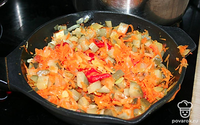 Нарезать огурцы и добавить в овощи на сковородке.