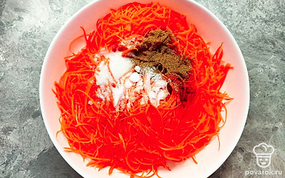 Переложите в глубокую посуду морковь. Добавьте к ней сахар, соль, перец и кориандр. Все хорошенько перемешайте и оставьте мариноваться на один час.