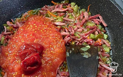 Затем добавляем колбасу, огурец, помидор и 2 столовые ложки томатной пасты. Жарим минут 5.