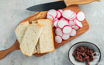 Подготовьте ингредиенты для тоста. Кусочки хлеба разрежьте пополам. Анчоусы измельчите. Редис нарежьте тонкими слайсами.