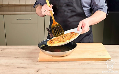 Проведите лопаткой по краям почти готовой тортильи (структура должна быть плотной, но с жидковатым верхом) и отделите ее от дна сковороды. Затем накройте сковороду тарелкой подходящего размера и одним ловким движением переверните тортилью на нее. Верните тортилью в сковороду другой стороной и готовьте на среднем огне еще пару минут.