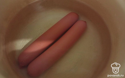 Сосиски отварите до готовности (10 минут с момента закипания воды) и очистите от пленки.