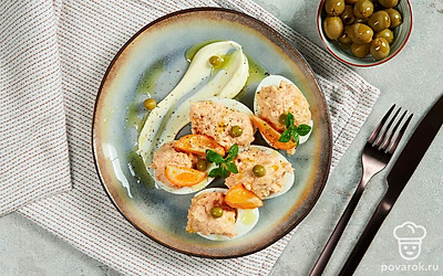 Яйца, фаршированные рыбой, оформите зеленым горошком.