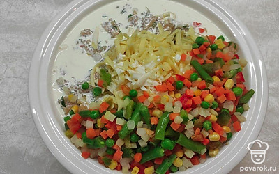 Добавьте сливки и желтки, снова хорошо вымесите фарш. Натрите на крупной терке сыр и половину его отправьте в смесь вместе с размороженными овощами.