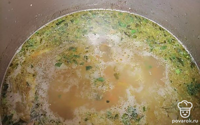 В кипящий бульон положите картофель. Через 10 минут закиньте лук, морковь и зелень. Добавьте соль и специи, варите еще 5 минут.

