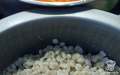 В кастрюлю с капустой выложить предварительно сваренную перловку и тушеные овощи из сковороды. Варить на самом малом огне еще 15 минут, крышкой не накрывают. Добавить приправу и зелень.