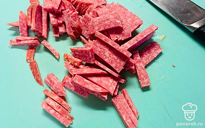 Нарежьте сервелат соломкой.