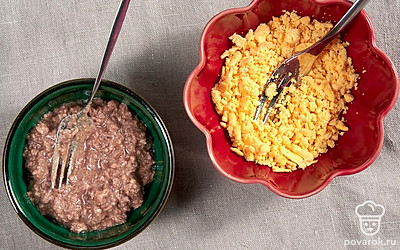 Подготовьте ингредиенты. Разрежьте яйца на половинки и удалите из них желтки. Отдельно разомните вилкой желтки и печень трески.